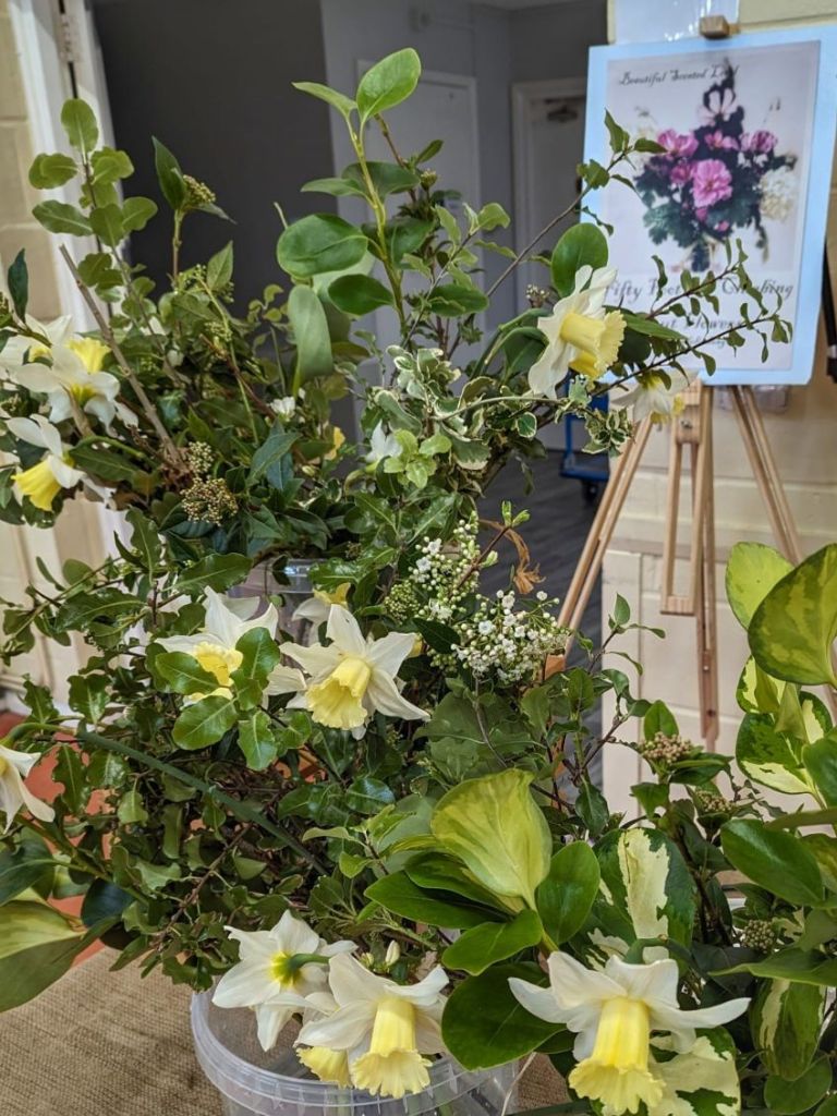 Close up of my bouquets for sale at the local farmers market. Showing freshly cat pale yellow and cream daffodils and white blossom with green and variegated foliage to complement